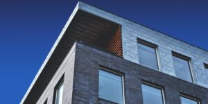 image of modern looking building slate siding, blue sky above.